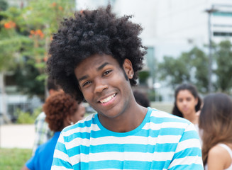 Fototapeta premium Laughing african man with multi racial group in the city