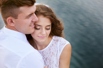 Fototapeta premium loving bride and groom walking on a background of lake
