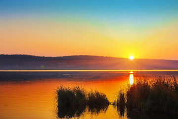Fototapeta na wymiar Beautiful sunset over calm lake. Dusk time