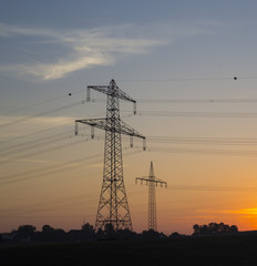 Fototapeta premium Stromleitung und Strommast, Sonnenaufgang