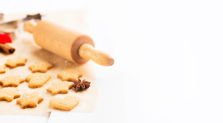 Homemade Christmas gingerbread cookies with festive decoration on white wooden background, selective focus. Holiday concept, toned
