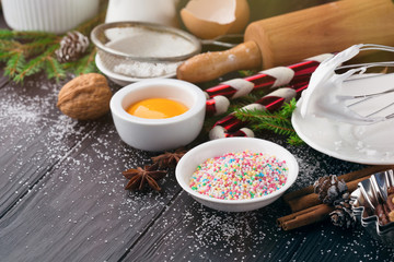 Baking ingredients for homemade Christmas pastry on dark rustic wooden background, selective focus. Bake sweet cake dessert concept. 