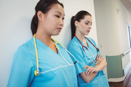 Sad nurse leaning against the wall