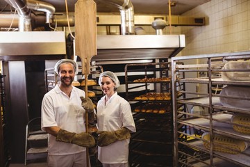 Portrait of female and male baker standing together