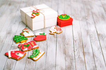 Christmas gift box with gingerbread cookies on white wooden back