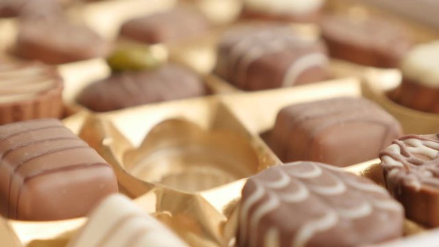 Picking one from chocolate box luxurious mix 4K 2160p 30fps UltraHD footage - Assorted candies packed and female hand choosing tasty one 3840X2160 UHD video 