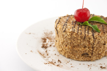 Layered cake with nut on plate, on white background. Selective f
