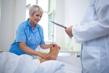 Nurse giving foot treatment to patient