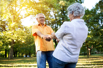 Senior couple having fun and dance in the park