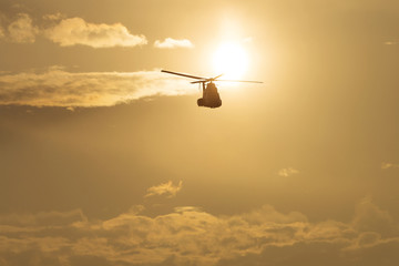 IAR Puma helicopter silhouette flying in the cloudy sky, stunt a