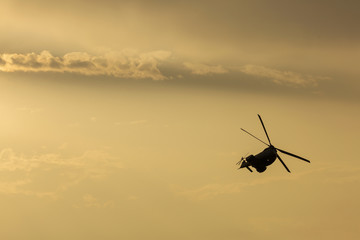 Fototapeta na wymiar IAR Puma helicopter silhouette flying in the cloudy sky, stunt a