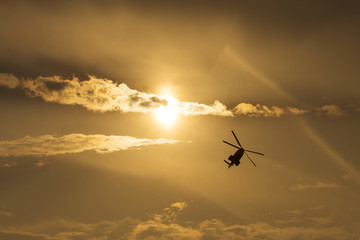 IAR Puma helicopter silhouette flying in the cloudy sky, stunt a