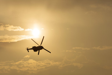 IAR Puma helicopter silhouette flying in the cloudy sky, stunt a