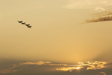 Silhouette of four formation of airplanes at sunset