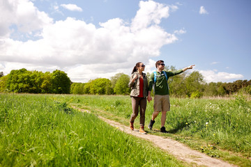 happy couple with backpacks hiking outdoors