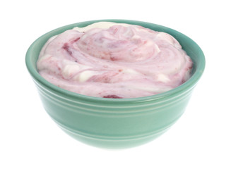 Raspberry yogurt in a bowl side view isolated on a white background.