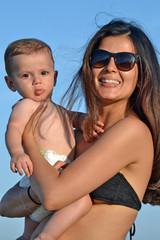 Madre con su bebe disfrutando juntos en la playa de vacaciones.