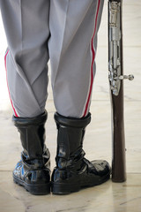 Military boots and rifle close up