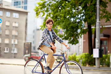 Fototapeta na wymiar young hipster man with bag riding fixed gear bike