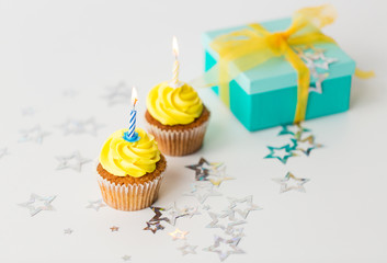 birthday cupcakes with burning candles and present