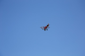Red WWI Fokker Triplane in Flight on clear blue Sky