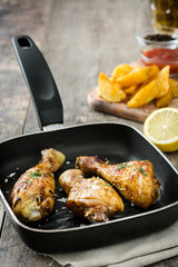 Roast chicken drumsticks on a fried pan


