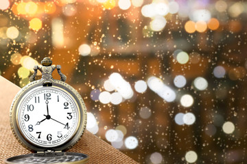 luxury vintage golden pocket watch on wood over blurred light bokeh background with warm light,abstract background for time concept with copy space