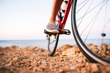 Naklejka na ściany i meble Closeup of cyclist woman legs riding bike on outdoor trail