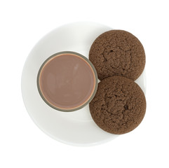 Glass of chocolate milk with cookies on a plate.