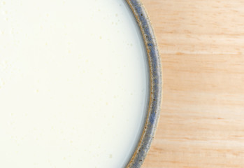 Bowl of buttermilk on a wood table.