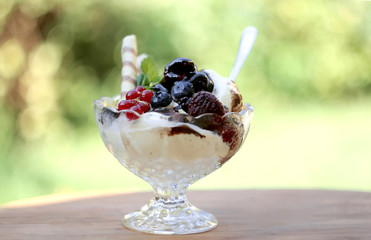 Ice cream with fresh fruits in crystal bowl 
