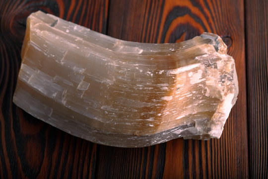 Crystal of Selenite isolated on wooden background