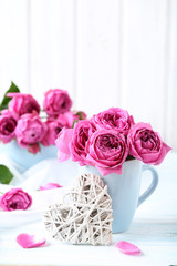 Beautiful pink roses on a white wooden table