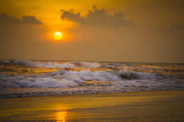 Fototapeta premium Sunset on the beach with waves crashing 2