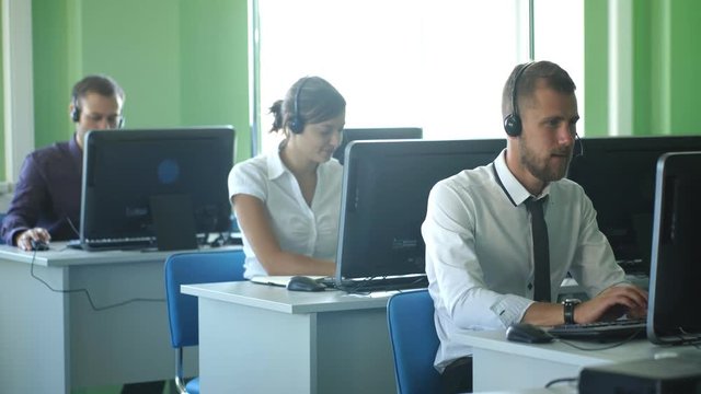 business colleagues with headsets using computers at the m dern office desk