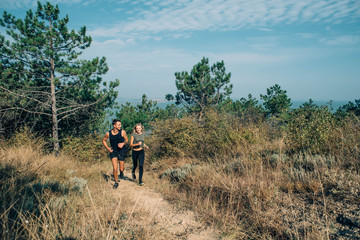 young sporty couple running in the wood 