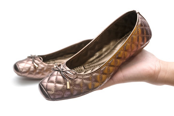 Woman hand holding new shoes isolated on white © praisaeng