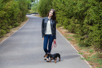young girl on a walk with her dachshund