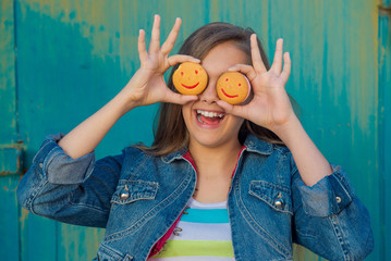 Cookies in the form of smiley. Teen girl eating cookies, snack for schoolchildren. Cheerful teen...