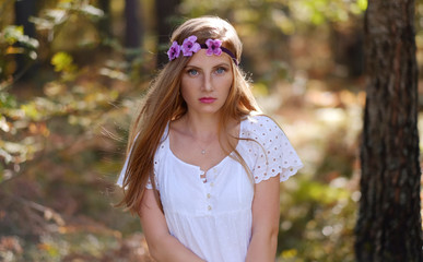 Freckled woman with circlet of flower on her head.