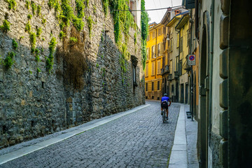 Cyclist riding on typical street of Bergamo italy