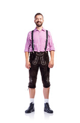 Handsome hipster man in traditional bavarian clothes, isolated