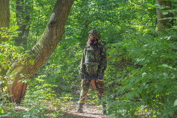 Fototapeta premium Bearded soldier with the gun in the forest