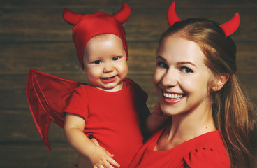 Family mother and baby son celebrate Halloween in devil costume