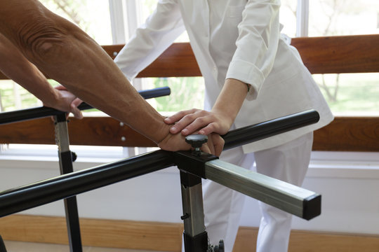 Adult doing a physical rehabilitation in a parallel bars