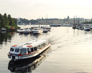 Fototapeta premium White civil passenger boat at the channel in summer