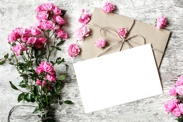 Bouquet of tender pink roses with a blank greeting card and envelope