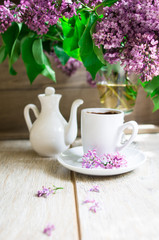 Fototapeta na wymiar Lilac flowers and cup of coffee
