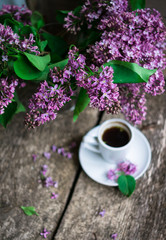 Lilac flowers and cup of coffee