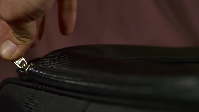 Woman's  Hand Zipping The Lid Of A Suitcase